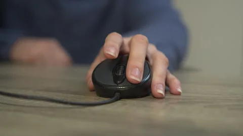 CloseUp Shot of a Hand Skillfully Using a Computer Mouse for Navigation and Stock Footage 318544021