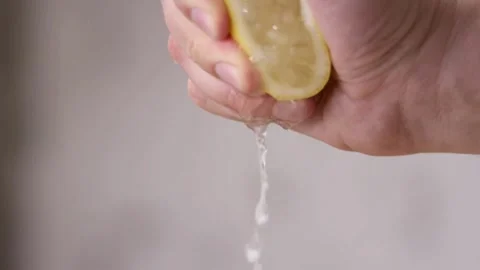 Closeup shot of hand squeezing lemon. Lemon juice coming out of lemon. Stock Footage 265839308
