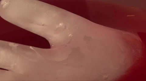 Closeup shot of hand touching ice in the form of a hand into the punch drink Stock Footage 68019415
