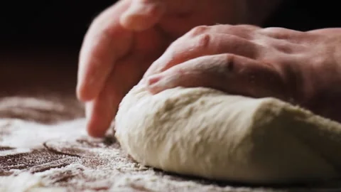 Closeup shot of hands of chef applying flour on dough. Man kneading dough Stock-Footage 147658373