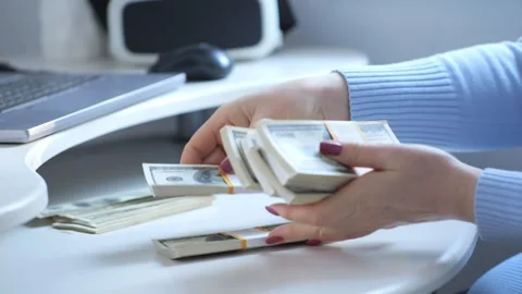 Closeup shot of hands counting stacks of 100dollar bills in an office, related Stock Footage 276845950
