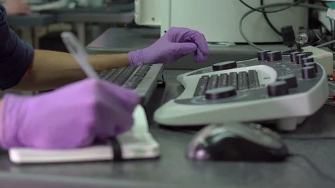 Closeup shot of hands of a scientist working on an scanning electron microscope. Stock Footage 77330026