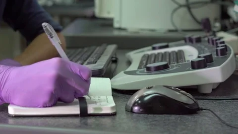 Closeup shot of hands of a scientist working on an scanning electron microscope. Stock Footage 77330151