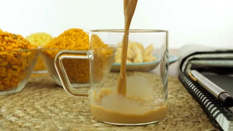 Closeup shot of hands serving hot masala chai in a glass cup with Indian snacks Stock-Footage 130838639