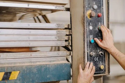 Closeup shot of hands working the buttons of an industrial machine Stock Photos