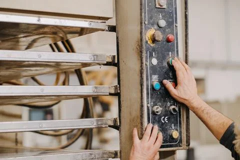 Closeup shot of hands working the buttons of an industrial machine Stock Photos