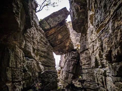 A closeup shot of huge rocks with the bumpy surface in a daytime under the cl Stockfoto's