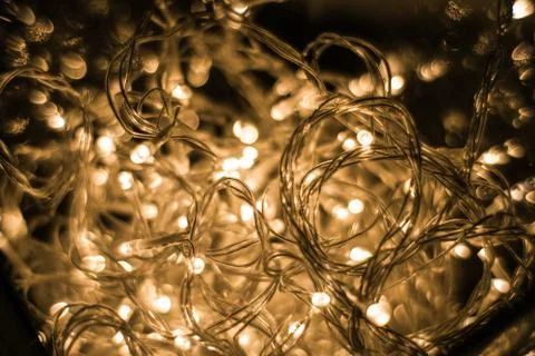 Closeup shot of illuminated string lights on a black background Stock Photos