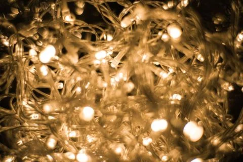 Closeup shot of illuminated string lights on a black background Stock Photos
