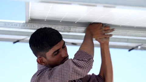 Closeup shot of Indian worker installing solar panels on roof of house. Mai.. Stock Footage 270870343