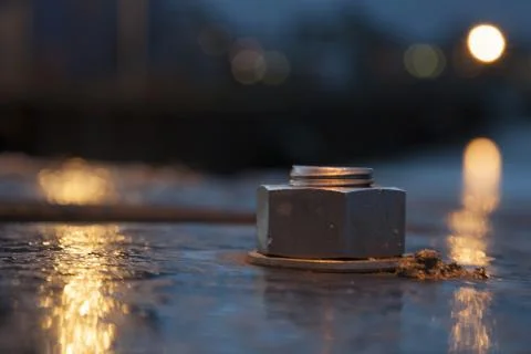 A closeup shot of an iron round objects attached to the ground with blurred b Stock Photos