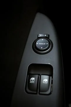 Closeup shot of knobs controlling windows and mirrors in car Stock Photos