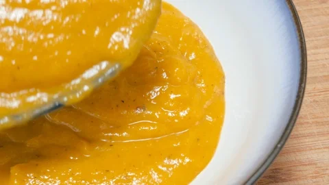 Closeup Shot Ladling Butternut Squash Soup Puree into a Ceramic Bowl in 4k Stock Footage 86256332