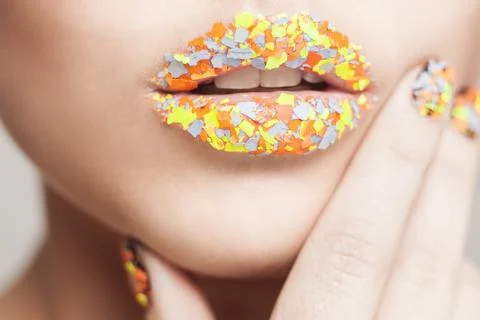 Closeup shot of lips with creative visage. orange, yellow and grey glitters.  Stock Photos