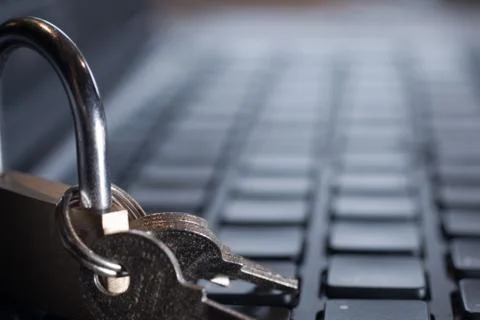 A closeup shot of a lock with keys on a computer keyboard - internet security Stock Photos
