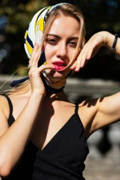 Closeup shot of luxury model with red lips wearing shawl and black dress posi Stock Photos