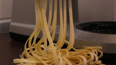 Closeup shot of making fresh pasta (spaghetti) on a pasta machine Stock Footage 169510854