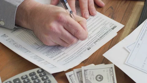 Closeup shot of man filling out income tax return at home. Stock Footage