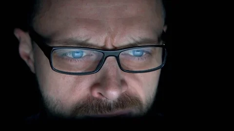 Closeup shot of man in glasses surfing internet at night Stock Footage 71298858