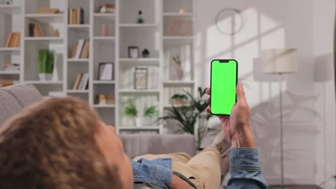 Closeup shot of a man lying on a sofa using a smartphone in a vertical position Video stock 249188216