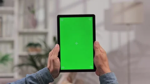 Closeup shot of a man lying on a sofa using a tablet in a vertical position with Video stock 249188397