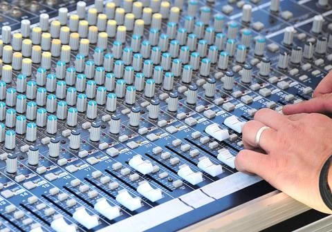 Closeup shot of man's hand on the sound mixing board managing the work of it Stock Photos