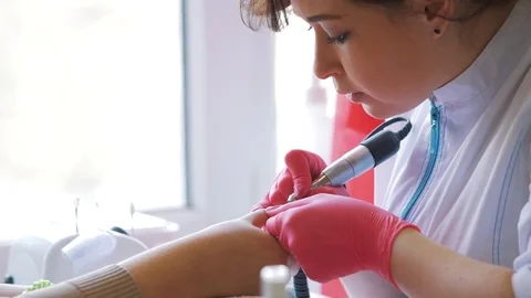 Closeup shot of master uses an electric machine to remove the nail polish during Stock Footage 73434680