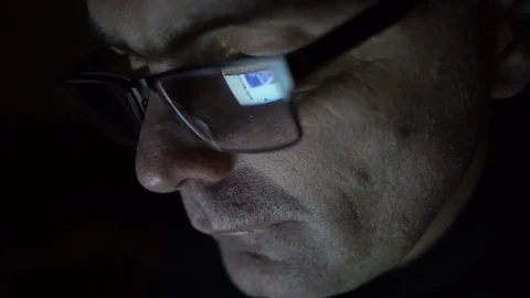 Closeup shot of middle age man in glasses surfing internet at night Stock-Footage 71991091