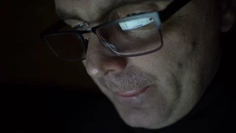Closeup shot of middle age man in glasses surfing internet at night Stock Footage 71995757