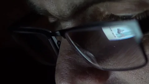 Closeup shot of middle age man in glasses surfing internet at night Video stock 71996758