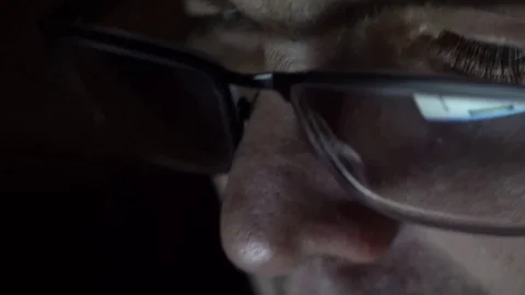 Closeup shot of middle age man in glasses surfing internet at night Video stock 71996931
