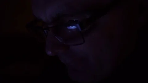 Closeup shot of middle age man in glasses surfing internet at night Video stock 72050052