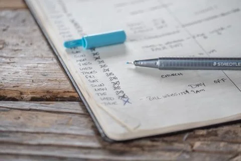 Closeup shot of an opened textbook with different dates and plans written in  Fotos de archivo