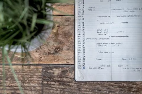 Closeup shot of an opened textbook with different dates and plans written in  Stock Photos