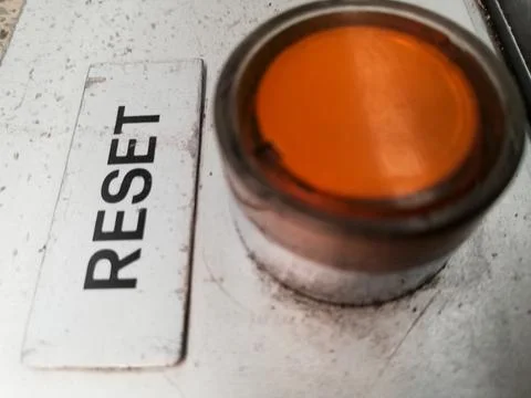 Closeup shot of an orange button to reset the operation and work of a machine Stock Photos
