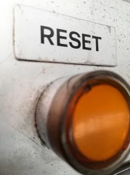 Closeup shot of an orange button to reset the operation and work of a machine Stock Photos