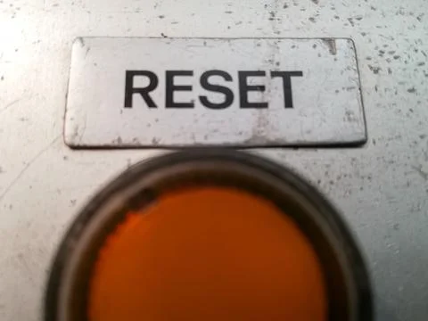 Closeup shot of an orange button to reset the operation and work of a machine Stock Photos