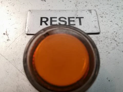Closeup shot of an orange button to reset the operation and work of a machine Stock Photos