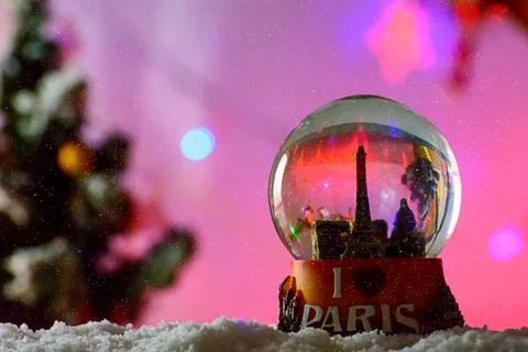 Closeup shot Paris Eiffel Tower Snow Globe Souvenir on the snowflakes on a blurr Stockfoto's