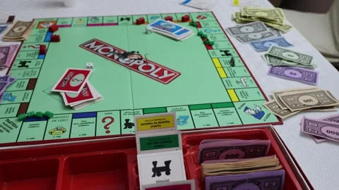 Closeup shot of a person rolling dice over a Monopoly board Stock Footage 271048861