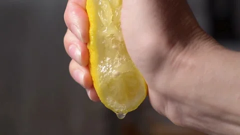 Closeup shot of person's hands squeezing lemon juice. Human squeezes half o.. Stock Footage 265838649