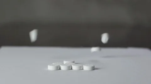 Closeup shot of pills dropping on a table Stock Footage 112655576
