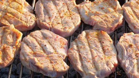 Closeup shot of the pork cutlets roasting on a barbecue grill in UHD Stock-Footage 112700356