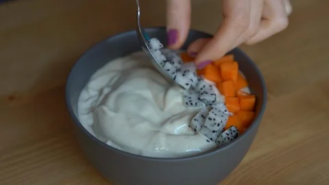 Closeup shot of a process of making a smoothie bowl with papaya, dragon fruit Stock Footage 107752545