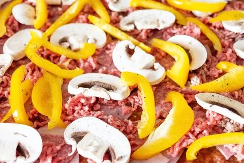 Closeup shot of a raw dish with beef, mushroom, and yellow bell pepper slices Stock Photos