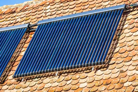 Closeup shot of a rooftop solar panel system for water heating under a sunlig Stock Photos