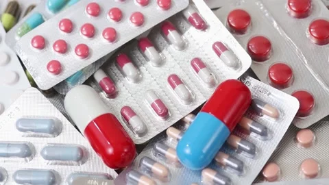 Closeup shot of rotating big pills on pile of medicine blisters Stock Footage 154309037
