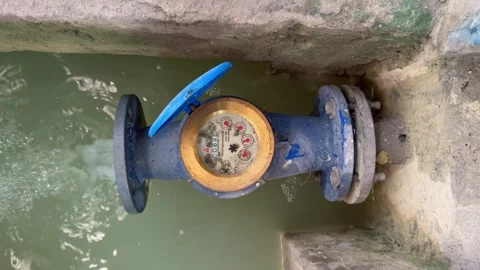 Closeup shot of running rotating dial analog water meter. Blue water flow meter Stock Footage 315419653