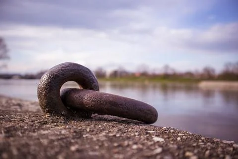 Closeup shot of a rusty metal Loop Mooring Ring Docking by water with blue sky o Foto stock