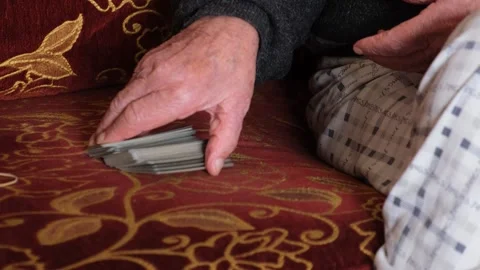 Closeup shot of a senior old man hand playimg cards at home Stock Footage 241210953